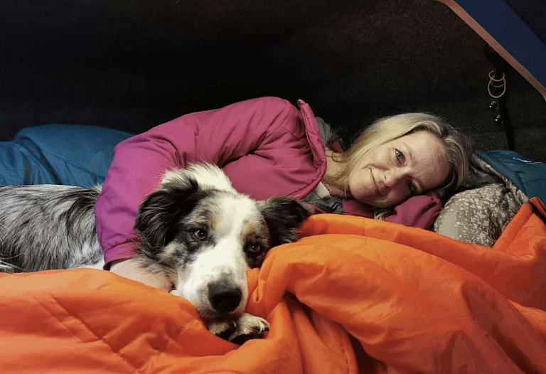 A woman lying on her bed with the dog